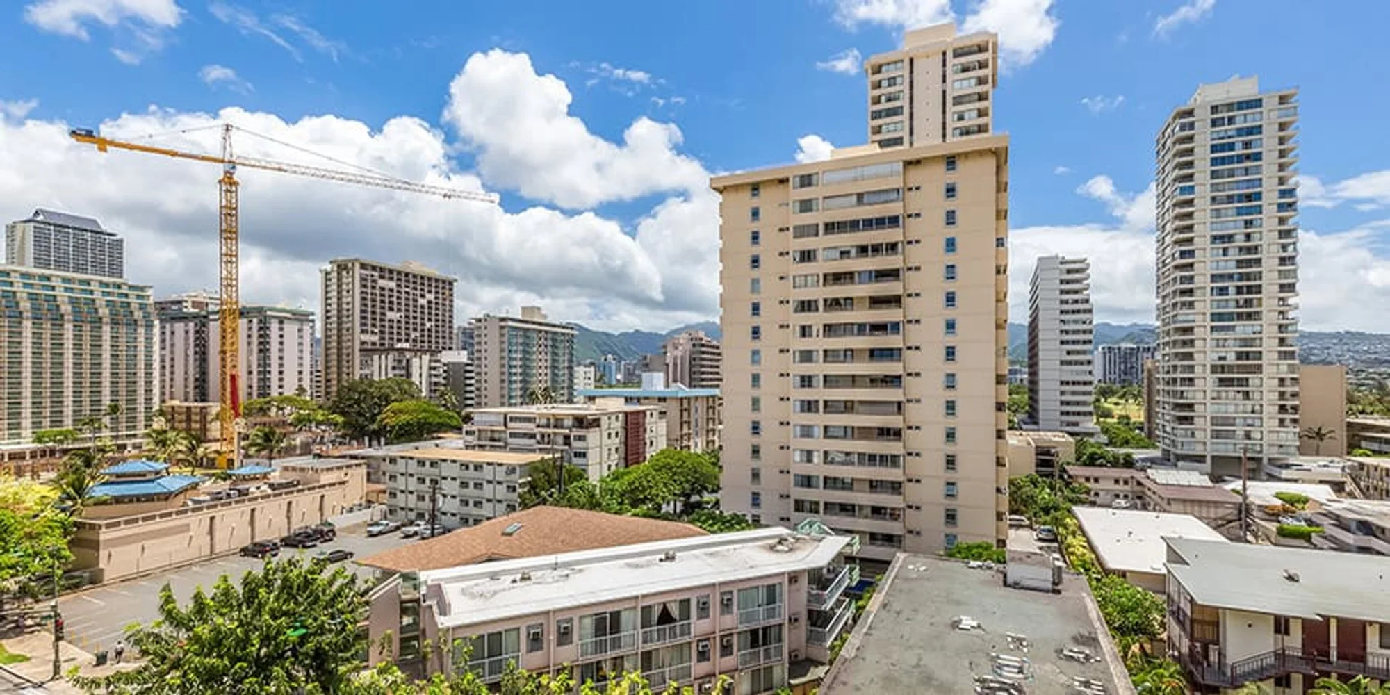 Waikiki Honolulu skyline with high-rise hotels, city streets, and Diamond Head in the distance under blue sky